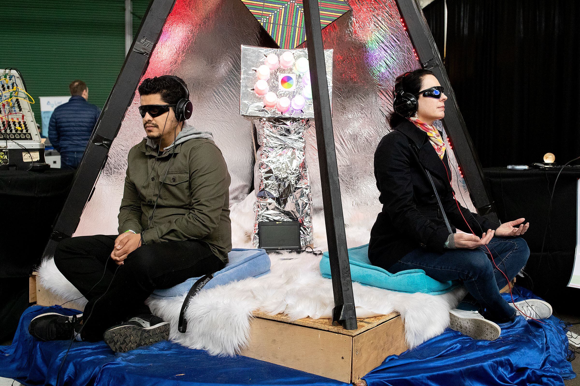 Los visitantes del Worlds Fair Nano prueban la pirámide AZoth, una máquina interactiva de inducción cerebral, durante el evento. Worlds Fair Nano es un festival del futuro cuya misión es que el público en general experimente el mañana. San Francisco, California, 11 de marzo, 2018.