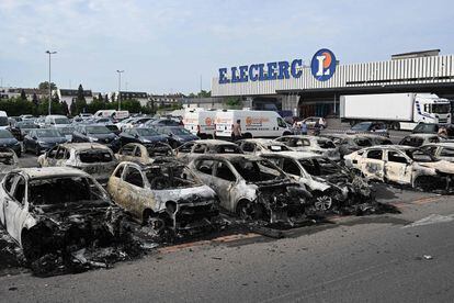 Vehículos incendiados en el aparcamiento de un supermercado de Schiltigheim, este jueves.