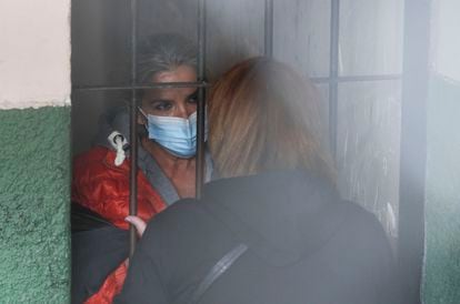 In a March 2021 file photo, former Bolivian President Jeanine Añez speaks to a woman from a cell at a police station in La Paz, Bolivia.