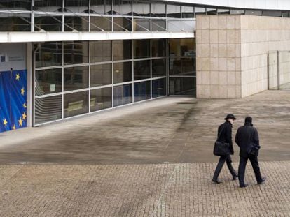 Dos hombres pasan cerca del edificio Berlaymont de la Comisión Europea, en Bruselas (Bélgica).