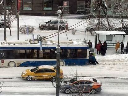 Los pasajeros empujan un trolebús atascado por la nieve en Moscú