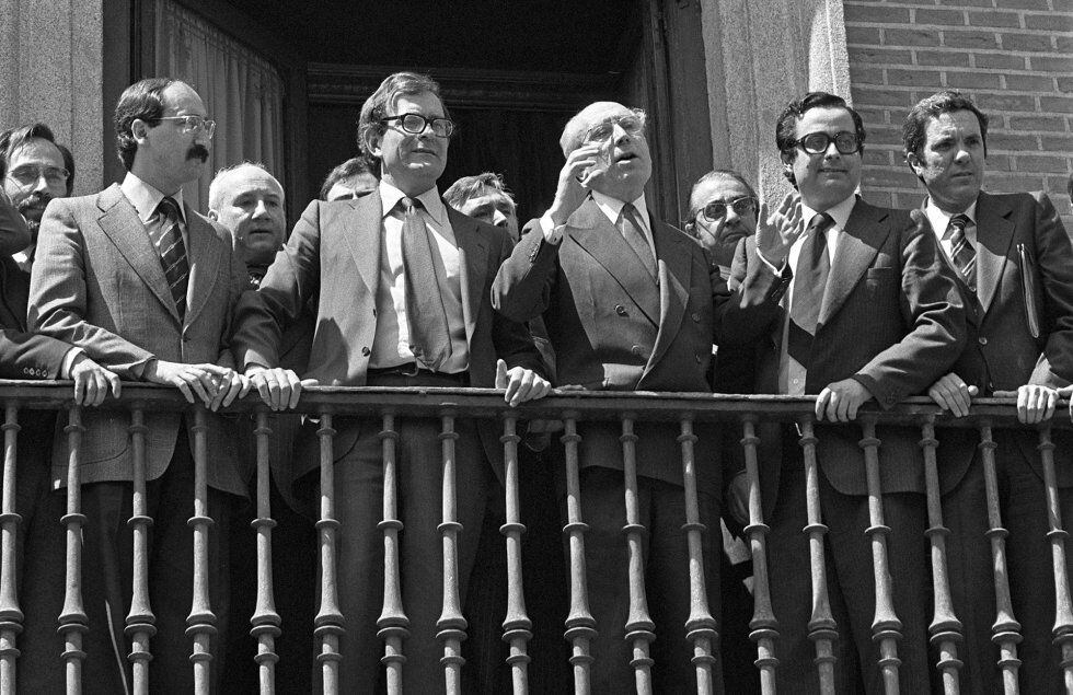 El nuevo alcalde de Madrid por el PSOE, Enrique Tierno Galván (tercero por la derecha), saluda desde el balcón del Ayuntamiento en la Plaza de la Villa de Madrid durante su toma de posesión, flanqueado por Alonso Puerta (segundo derecha) y Ramón Tamames (segundo izquierda) y José Barrionuevo (derecha), el 14 de abril de 1979.