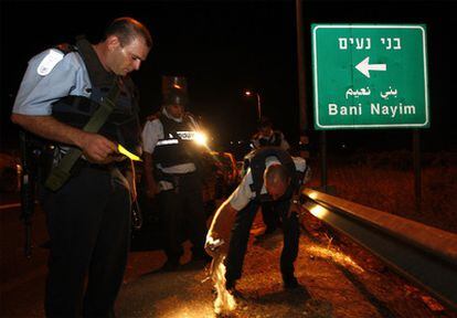 Un policía israelí investiga el asesinato de cuatro colonos a la entrada del asentamiento de Kiryat Arba, cerca de la ciudad de Hebron