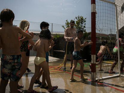 Un profesor refrescando a los alumnos en una escuela de Barcelona en junio, durante la ola de calor.