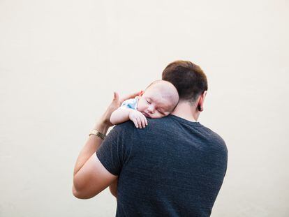 Un padre coge en brazos a su bebé.