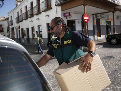 Un guardia civil con una caja de evidencias tras registrar el Ayuntamiento de Valdemoro. 