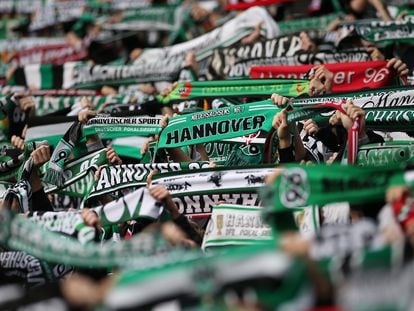 Aficionados del Hannover 96 levantando sus bufandas durante un partido de la Bundesliga.