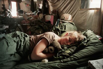 La enfermera Amy Stuart abraza un oso de peluche mientras duerme en una unidad quirúrgica móvil durante la Guerra del Golfo, Arabia Saudí, 1991.