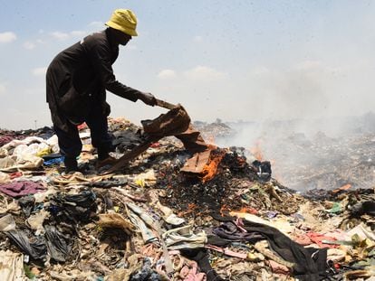 Un hombre quema unos pantalones en el vertedero de Dandora, en Nairobi (Kenia), el pasado 19 de septiembre.