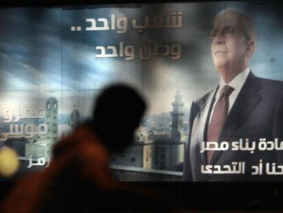 Un transe&uacute;nte ante un cartel de Amr Musa, en El Cairo.