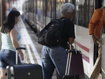 Varias personas montan a un tren en la estación de Chamartín, en Madrid.