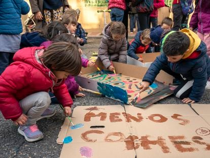 Alumnos y sus familias del colegio Menéndez Pelayo, de Madrid, preparan carteles para participar en la Revuelta Escolar contra los coches, este viernes.