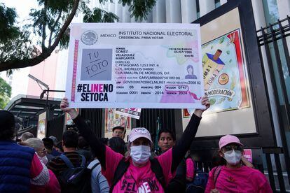 Una manifestante levanta un cartel durante una protesta en contra de la reforma electoral, el 13 de diciembre de 2022.