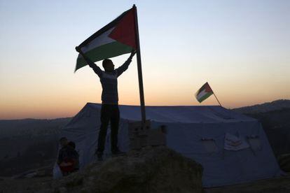 Un activista alza una bandera palestina en el campamento de Beit Iksa, cerca de Ramala. 