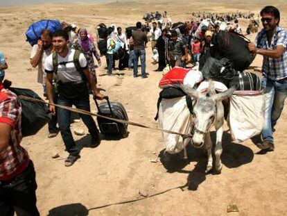 Refugiados sirios cruzan la frontera con el Kurdistán irakí.