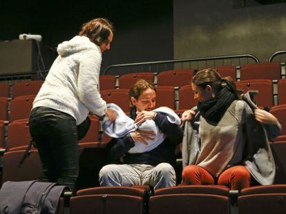 Iglesias sostiene el bebé de Carolina Bescansa (de pie), junto a otra compañera, Irene Montero, ayer en una sala de cine, en Madrid.