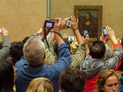 Decenas de turistas fotograf&iacute;an la Mona Lisa en el Louvre.