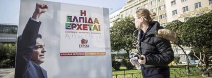 Una joven observa un cartel electoral del líder de Syiza, Alexis Tsipras, en el centro de Atenas (Grecia) el viernes 23 de enero de 2015.