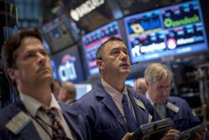 Parqu&eacute; del NYSE, con dos &#039;traders&#039; mirando serios al infinito de los monitores.