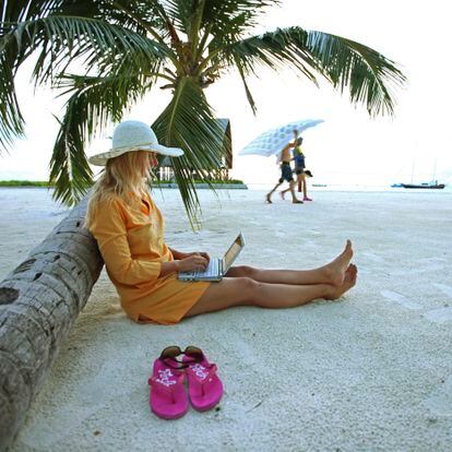 A woman works on her dresser at Villingili beach in the Maldives