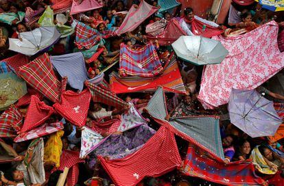 Devotos hindúes colocan sus paraguas para recibir arroz durante el festival Annakut, en Calcuta (India)