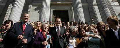 El presidente del Gobierno, José Luis Rodríguez Zapatero, y el ministro de Asuntos Sociales, Jesús Caldera, posan con un grupo de mujeres en la puerta del Congreso de Los Diputados.