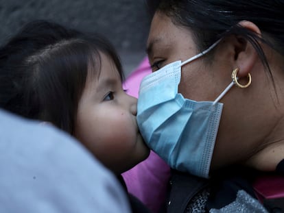 Una mujer migrante y un niño se besan durante una reunión para solicitar al gobierno de Chile regular su estatus migratorio antes de que se publique una nueva regla que facilite la expulsión del país, según medios locales, durante la pandemia, en Santiago, Chile, el12 de abril de 2021.