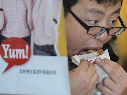 Un hombre consume pollo frito en una cadena de comida r&aacute;pida en Shanghai.