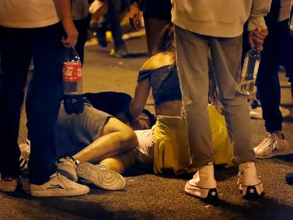 Un joven es atendido por sus amigos en un botellón en Maria Cristina, durante La Mercè.