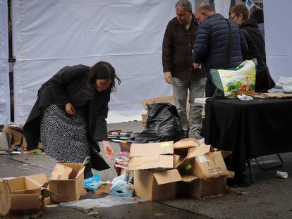 Libreros recogiendo ejemplares mojados después de la tormenta en el día de Sant Jordi, este sábado.