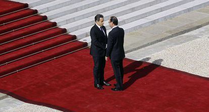 Nicolas Sarkozy recibe al pie de las escaleras del Elíseo al presidente electo François Hollande.