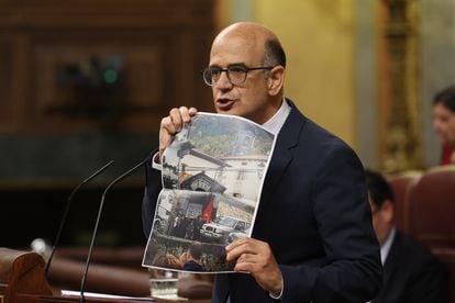 El diputado de Unión del Pueblo Navarro (UPN) en el Congreso, Alberto Catalán, muestra una foto de una protesta contra la Amnistía durante su intervención en el debate de investidura de Pedro Sánchez.