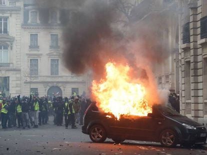 Un coche ardiendo en la protesta de los 'chalecos amarillos', cerca del Arco del Triunfo en París. En vídeo, más de 700 detenidos en una movilización de con más de 30.000 participantes.