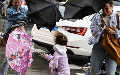 Varias personas tratan de dominar sus paraguas en San Sebastián.