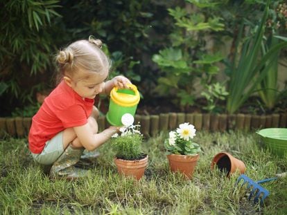 Una niña riega sus plantas.