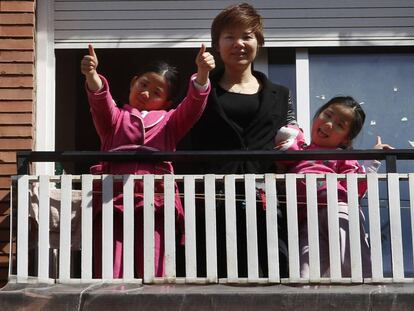 Wei Chen i les seves filles saluden des de la finestra del pis on viuen al Fort Pienc. 