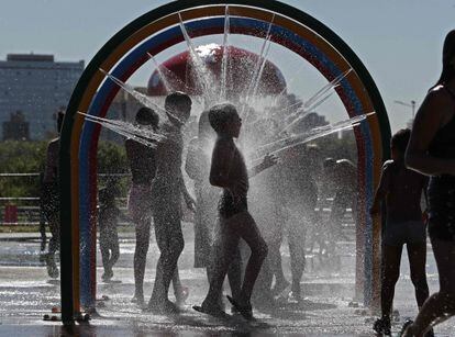 Niños se refrescan en una fuente, en Buenos Aires, el 13 de enero de 2022, durante una ola calor.