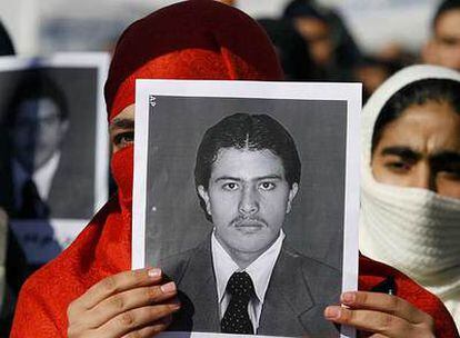 Una manifestante contra la ejecución de Parwez sostiene su foto.