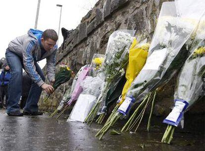 Un hombre deposita un ramo de flores en el lugar donde dos soldados británicos fueron asesinados a tiros por el IRA-Auténtico.
