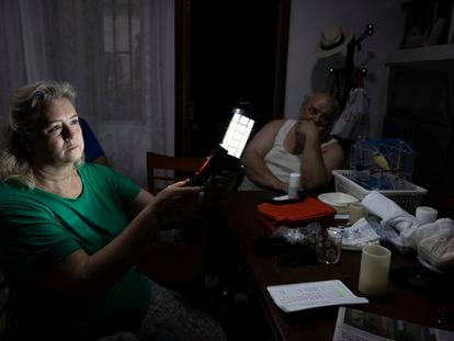 Rocío Barragán, vecina del barrio de Palmete de Sevilla que sufre frecuentes cortes de luz, enciende una linterna junto a su esposo Antonio Rincón, este miércoles.