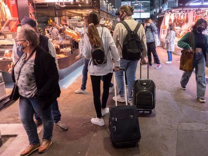 BARCELONA 2021/05/17 Turismo en Barcelona tras superar los peores momentos de la pandemia del  Covid-19. En la imagen, dos turistas italianos paseando por el mercado de la Boqueria acarreando maletas.  *Foto:Carles Ribas* 