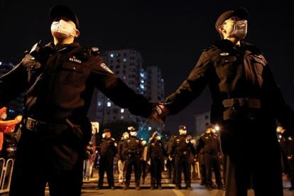 Agentes vigilan la marcha en Pekín. Decenas de policías han conducido a los manifestantes en dirección al río Yongding, donde han continuado las protestas.