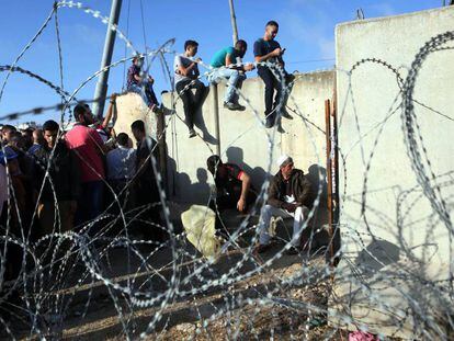 Un grupo de palestinos espera a pasar el puesto de control de Kalandia para visitar la mezquita Al-Aqsa durante el Ramadán en 2016.