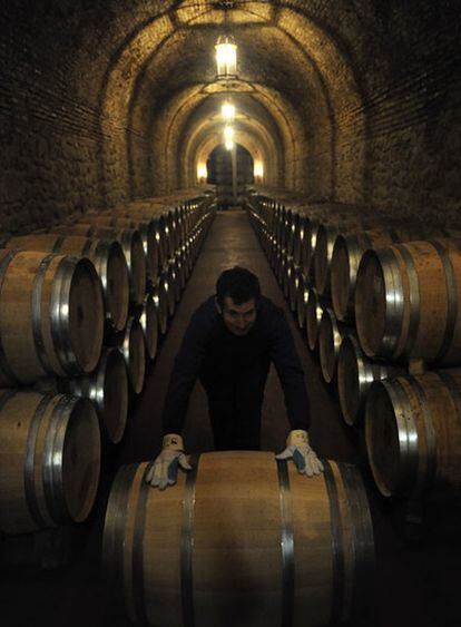 Un empleado coloca barricas de vino, en una bodega de Cenicero, en La Rioja.