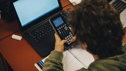 Un alumno usa una calculadora en clase. 
