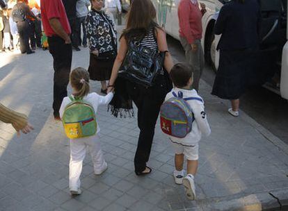 Una mujer lleva a sus dos hijos al colegio Sagrado Corazón en su primer día de clase, el curso pasado.