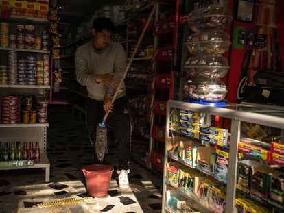 Un joven hace el aseo en una tienda en Soacha (Colombia), en mayo de 2023.