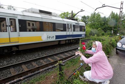 Una mujer coloca flores en el lugar del atropello ferroviario de dos mujeres en Torrelavega.