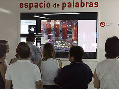 Varias personas dejan sus mensajes en el espacio habilitado en la estación de Atocha.