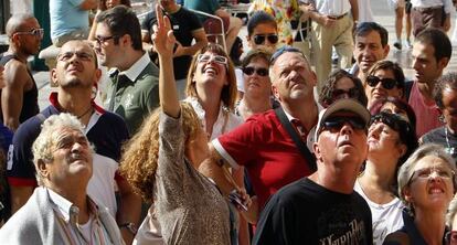 Cruceristas llegados a Valencia escuchan a una guía bajo la catedral de Valencia.